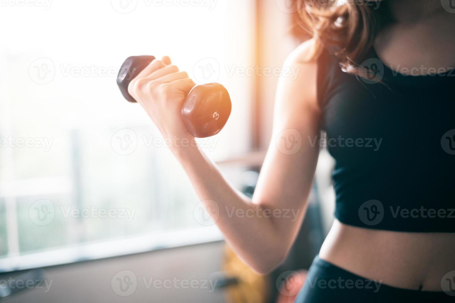 main de femme sportive soulevant des haltères photo