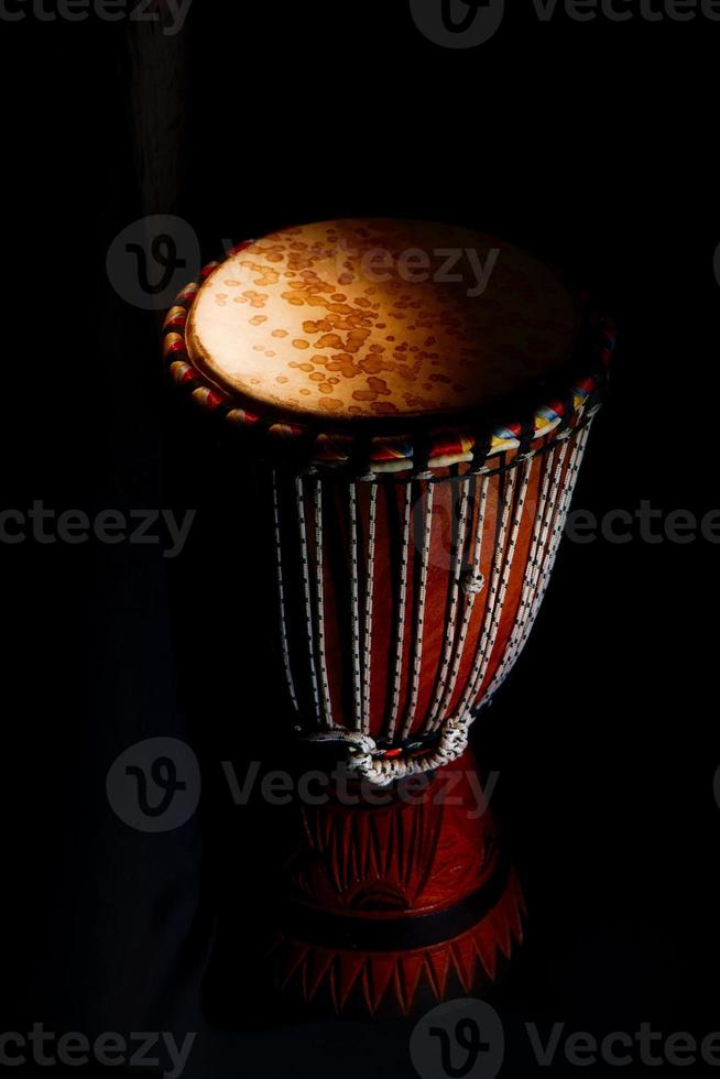 djembé. percussions africaines typiques sur fond noir photo