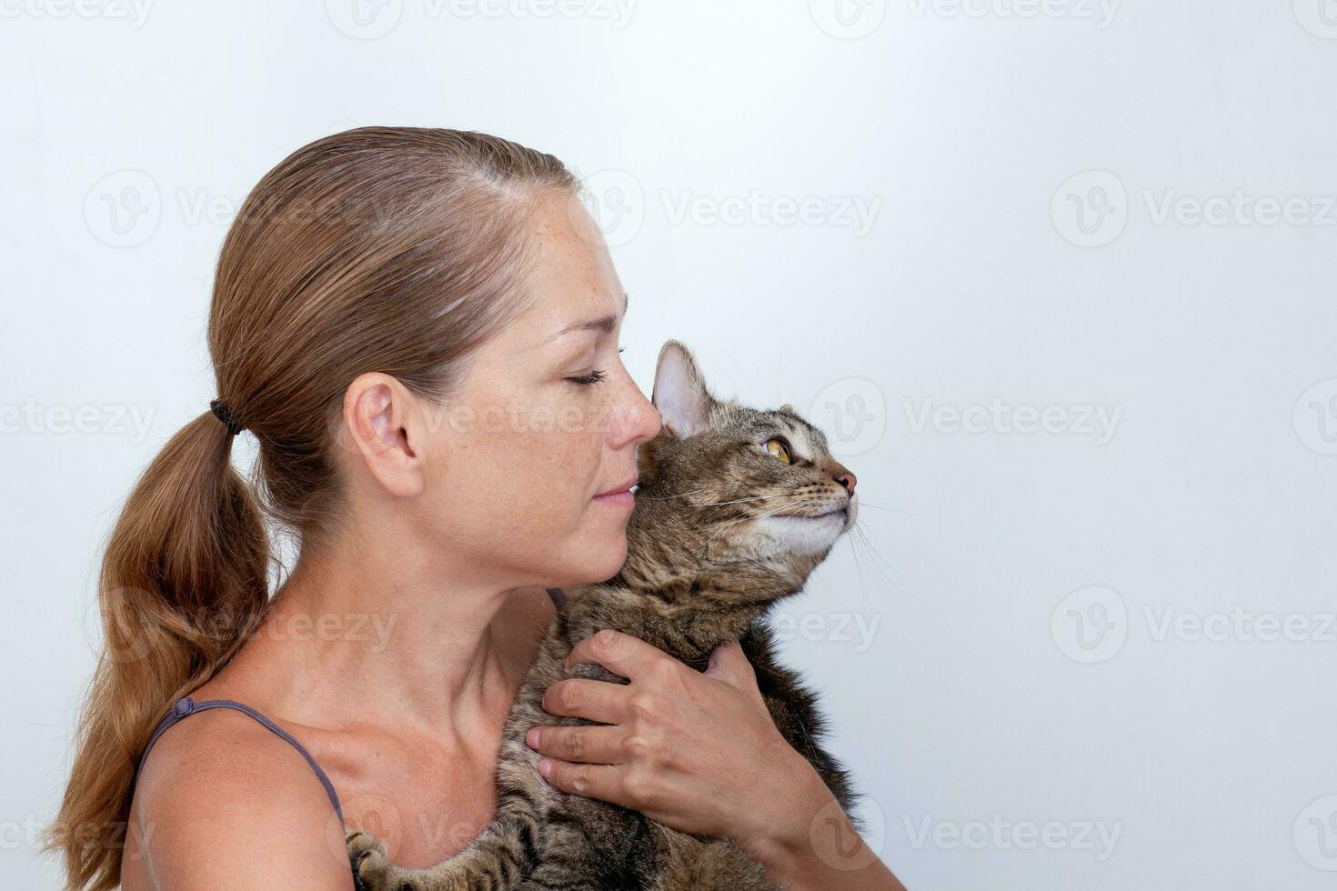 femme étreindre chat à la recherche de côté sur blanc Contexte photo