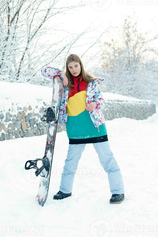 Jeune femme en portant snowboard sur sa épaules photo