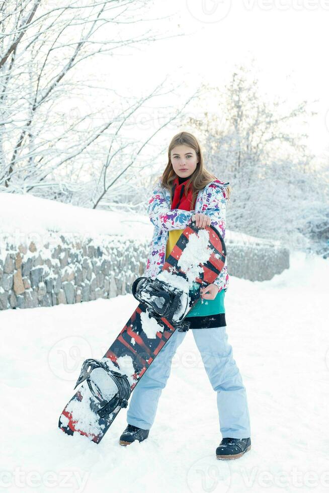 Jeune femme en portant snowboard sur sa épaules photo