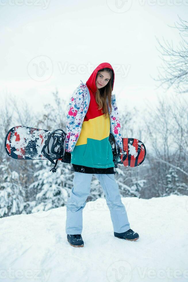 Jeune femme en portant snowboard sur sa épaules photo