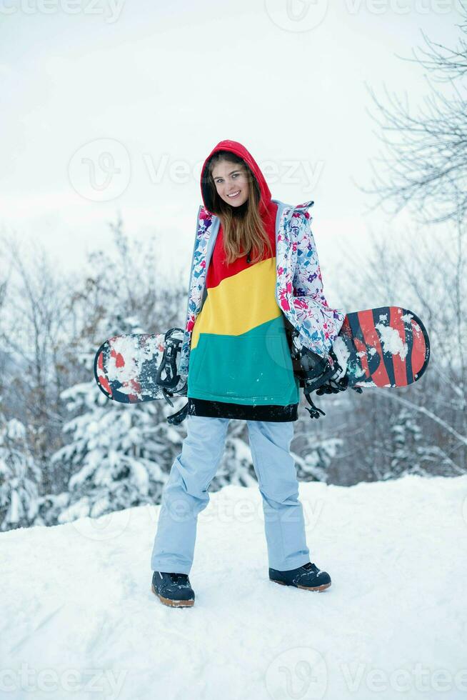 Jeune femme en portant snowboard sur sa épaules photo