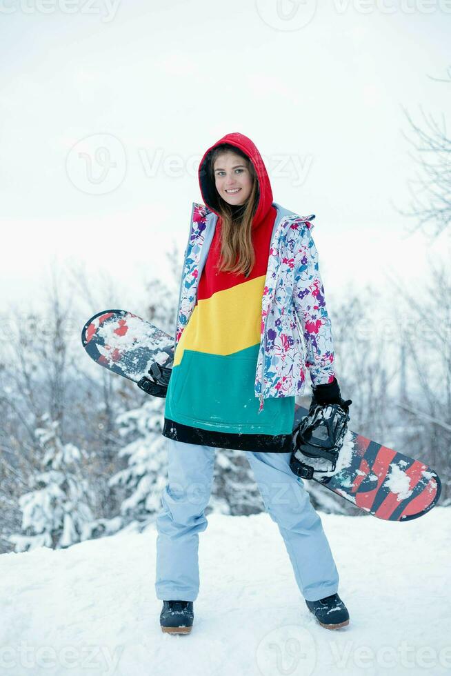 Jeune femme en portant snowboard sur sa épaules photo