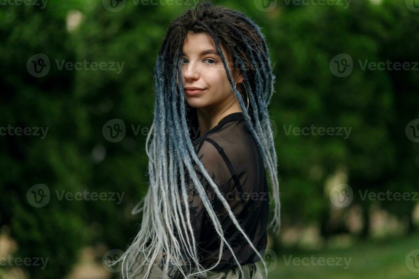 de bonne humeur caucasien fille à la recherche à le caméra et souriant modèle avec dreadlocks photo