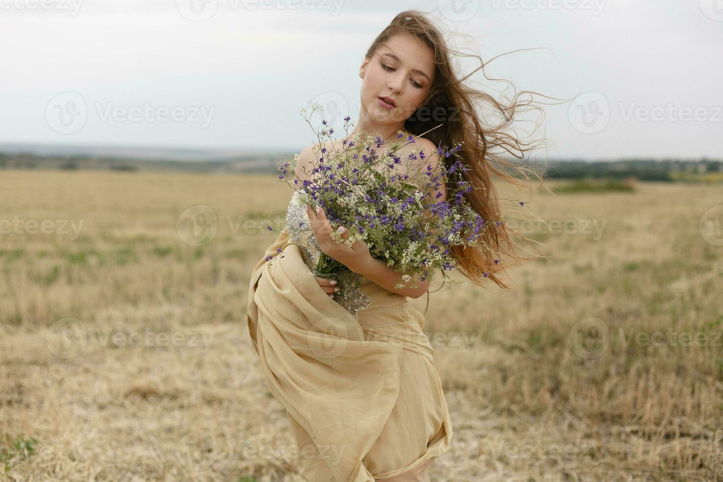 femme en marchant dans d'or séché herbe champ. photo