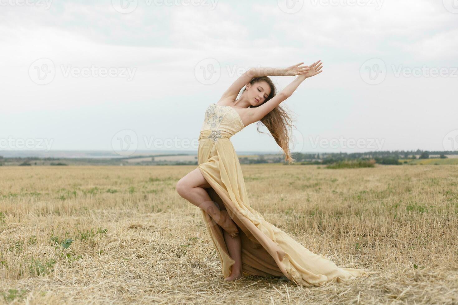 femme en marchant dans d'or séché herbe champ. photo