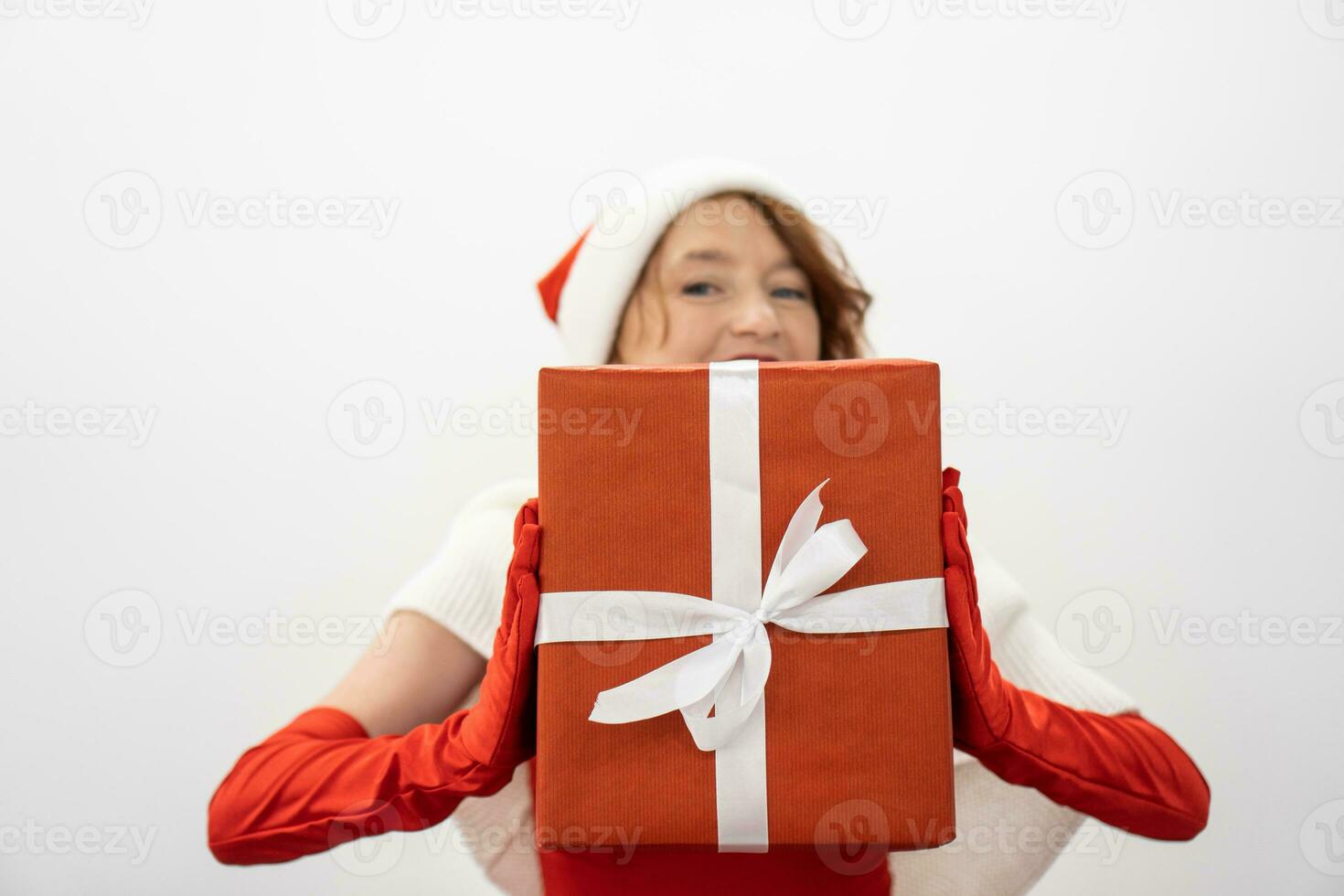 souriant légèrement, elle détient une cadeau dans sa mains, lequel volonté devenir un expression de l'amour et se soucier pour aimé ceux pour le Nouveau année et Noël. contre le Contexte de une blanc feuille de papier, le photo