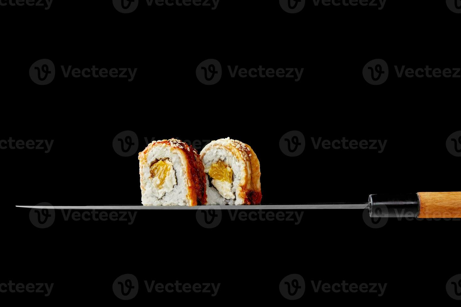 deux unagi Rouleaux avec crème fromage et Orange sur lame de Japonais couteau photo