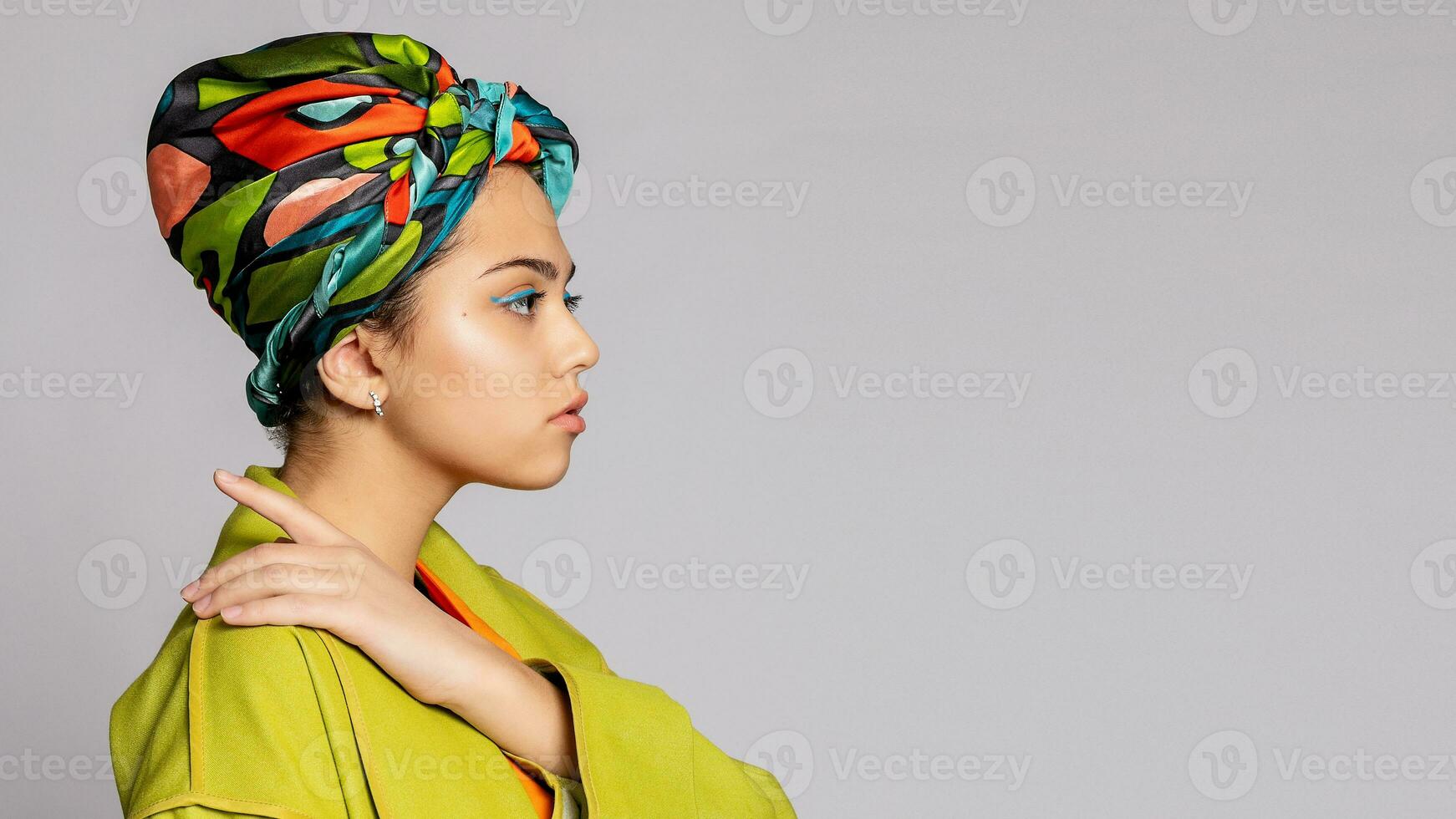 portrait de une Jeune femme avec brillant maquillage et une à la mode foulard. photo