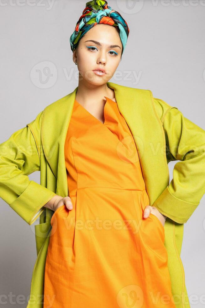 portrait de une Jeune femme avec brillant maquillage et une à la mode foulard. photo