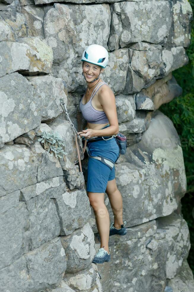 une fille grimpe une rock. femme engagé dans extrême sport. photo