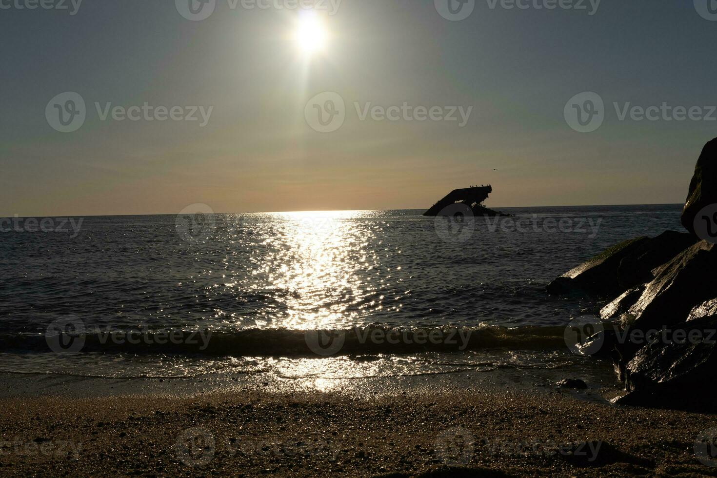 le coucher du soleil plage dans cap mai Nouveau Jersey où vous pouvez avoir une génial vue de le Soleil Aller vers le bas à travers le océan et le baie. le réflexion de le Soleil sur le l'eau avec le creux navire regards donc belle. photo