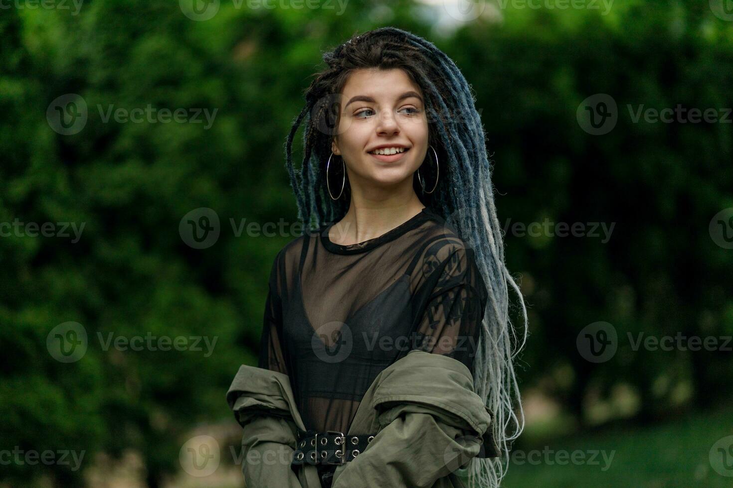 de bonne humeur caucasien fille à la recherche à le caméra et souriant modèle avec dreadlocks photo