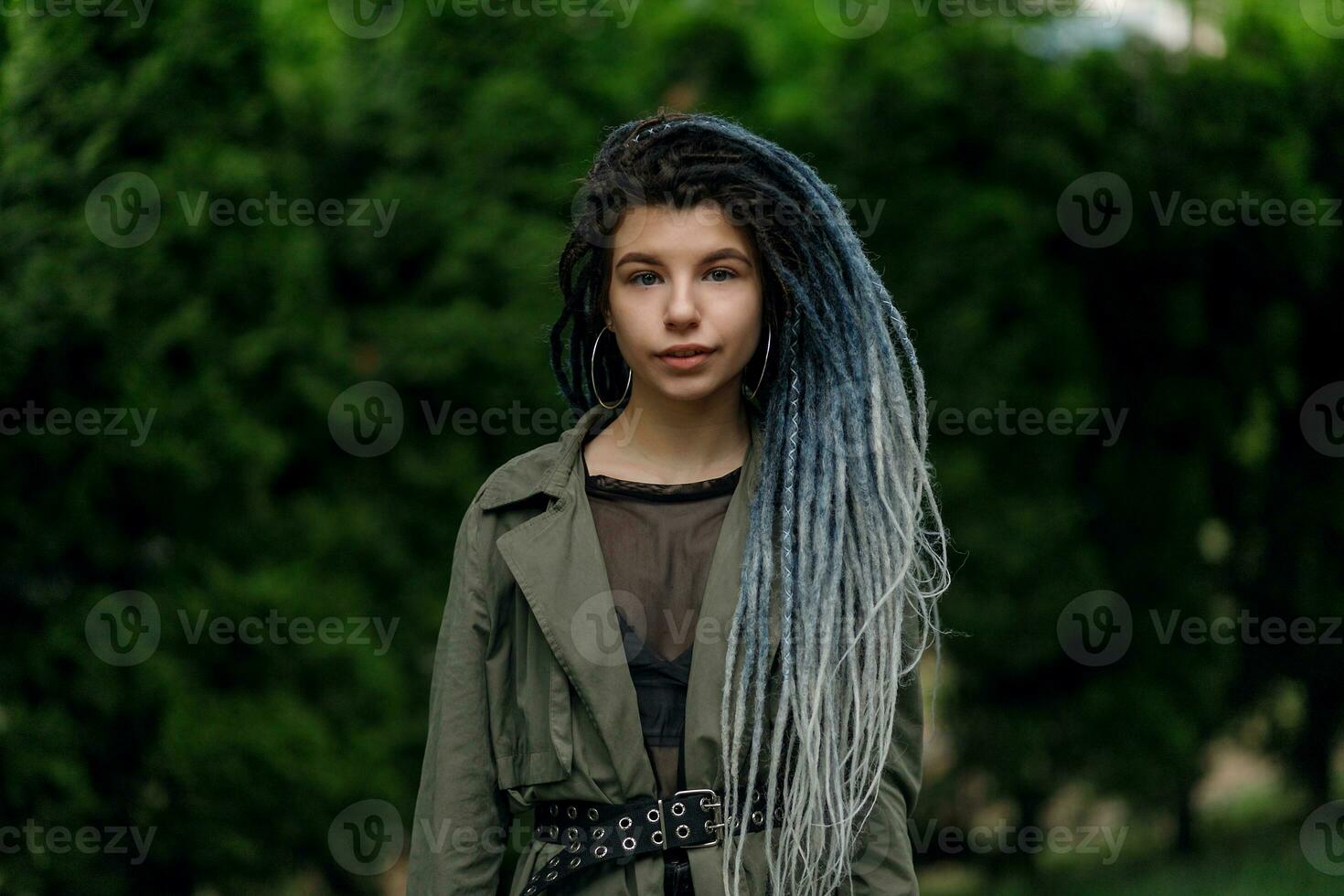 de bonne humeur caucasien fille à la recherche à le caméra et souriant modèle avec dreadlocks photo