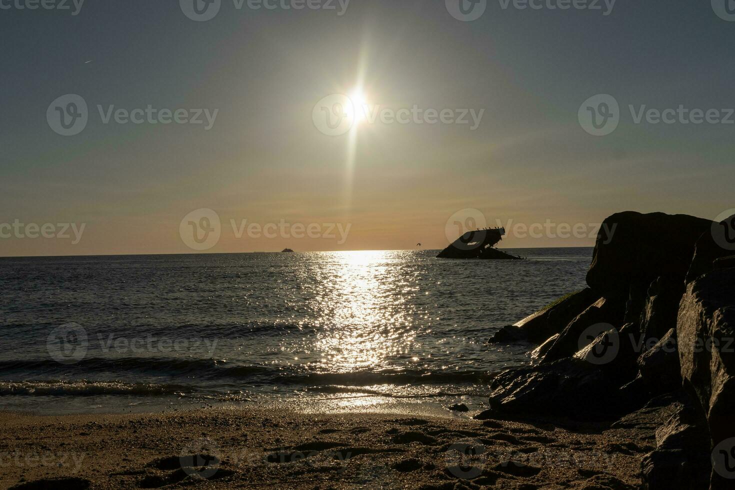 le coucher du soleil plage dans cap mai Nouveau Jersey où vous pouvez avoir une génial vue de le Soleil Aller vers le bas à travers le océan et le baie. le réflexion de le Soleil sur le l'eau avec le creux navire regards donc belle. photo