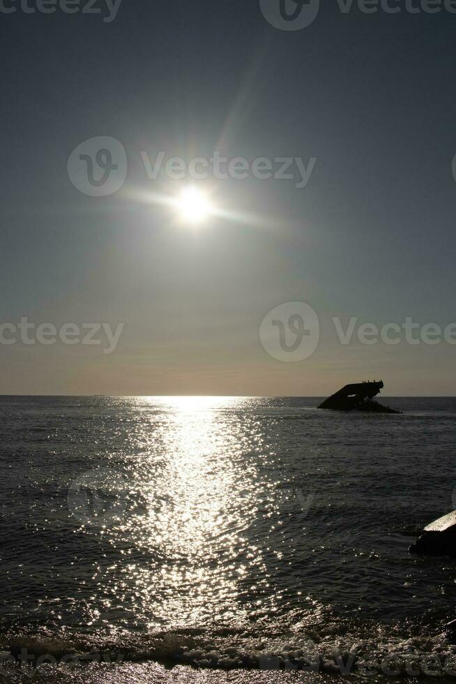 le coucher du soleil plage dans cap mai Nouveau Jersey où vous pouvez avoir une génial vue de le Soleil Aller vers le bas à travers le océan et le baie. le réflexion de le Soleil sur le l'eau avec le creux navire regards donc belle. photo