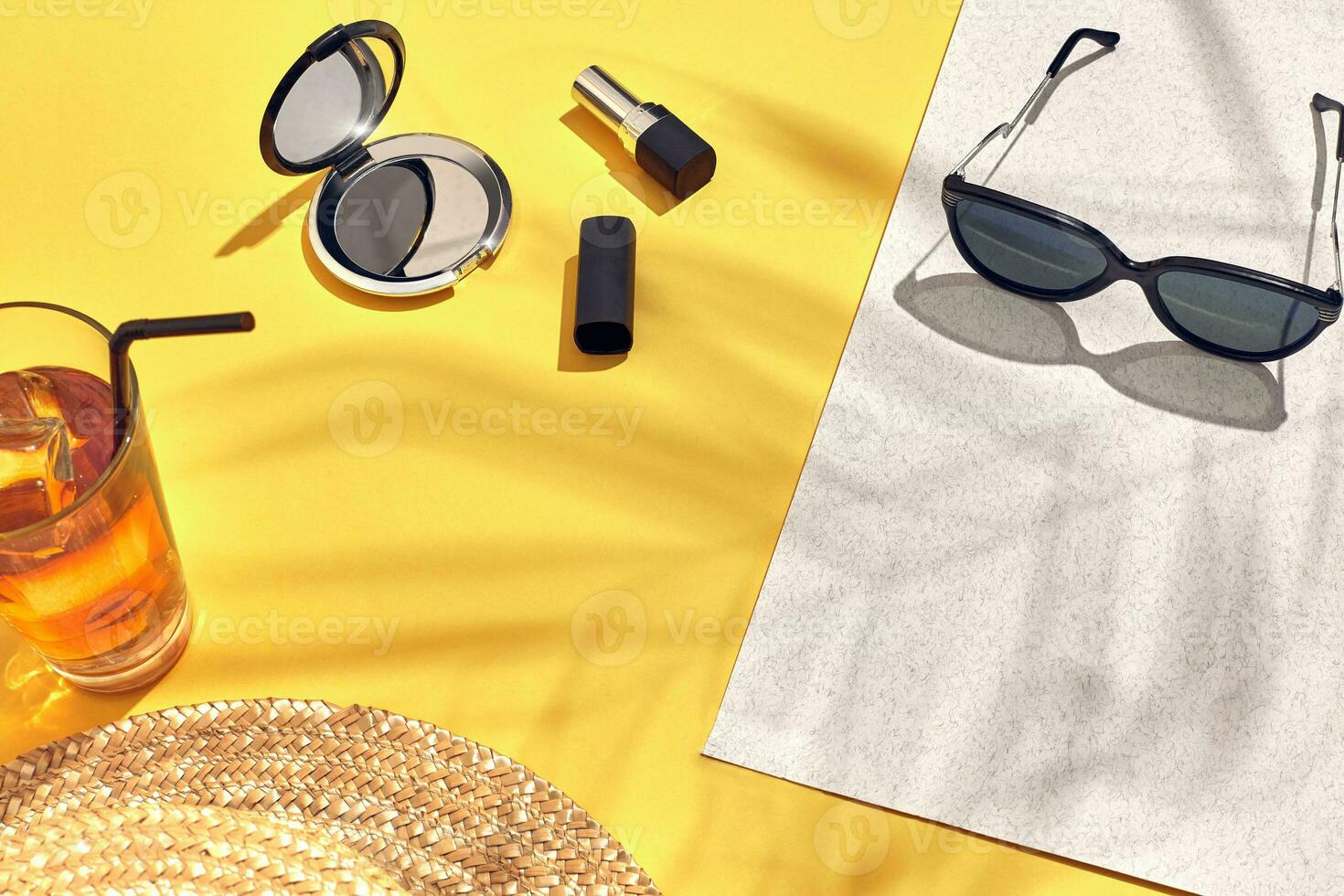 paille plage femme chapeau et Soleil lunettes, Haut vue Jaune et blanc papier Contexte avec ombre de une paume feuille. photo