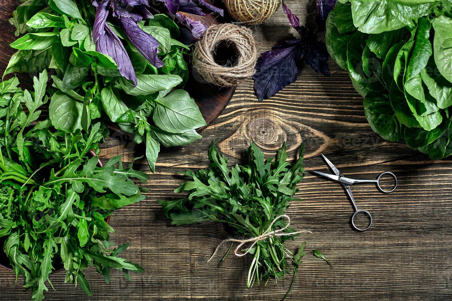 variété de Frais biologique herbes sur en bois Contexte. fraîchement récolté herbes comprenant basilic, Roquette. Haut voir. copie espace. photo