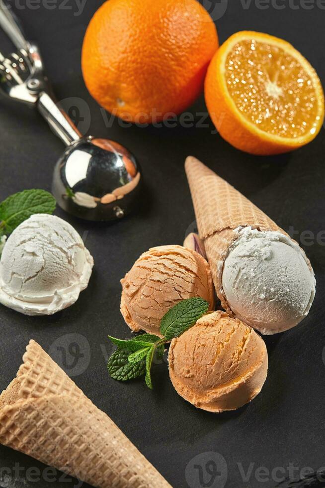 fermer coup de une crémeux et Orange la glace crème servi sur une foncé ardoise, noir Contexte. photo