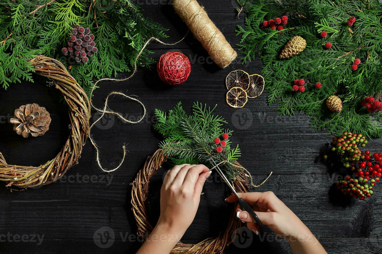 fabricant de Noël décor avec leur posséder mains. Noël couronne pour le vacances. le Nouveau année fête. Haut vue photo