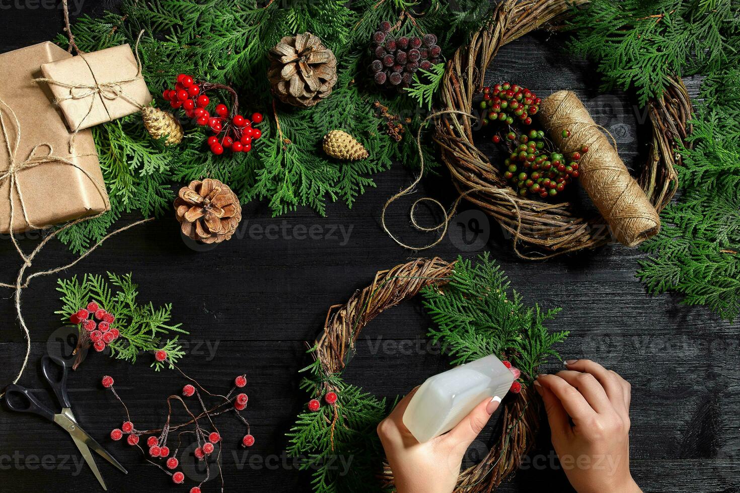 fabricant de Noël décor avec leur posséder mains. Noël couronne pour le vacances. le Nouveau année fête. Haut vue photo