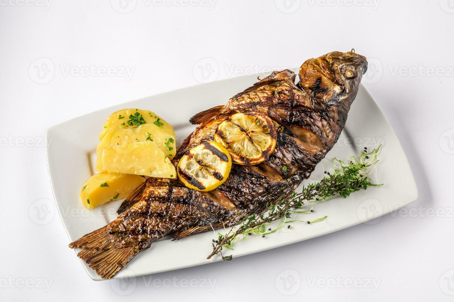 grillé carpe poisson avec Romarin patates et citron, proche en haut photo