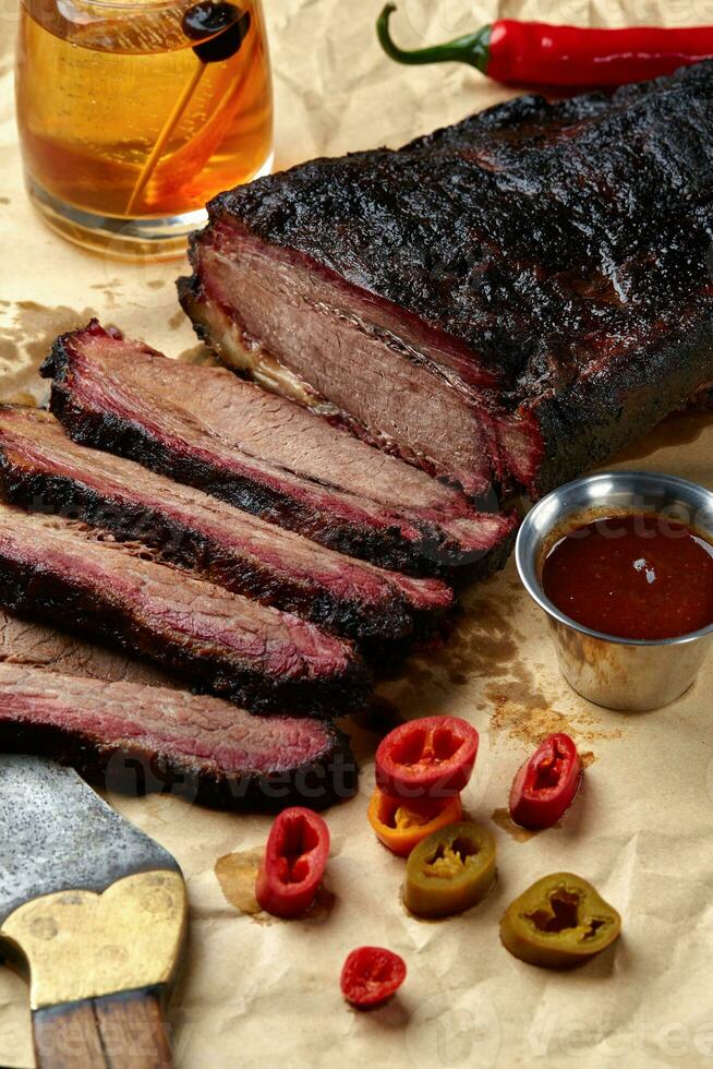 Frais pointe de poitrine un barbecue du boeuf tranché pour portion contre une kraft papier Contexte avec sauce, chaud poivrons et maïs. photo