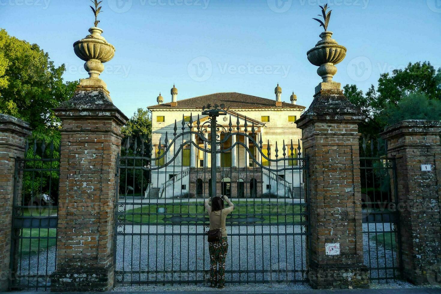 une homme permanent dans de face de une porte avec une statue dans le Contexte photo