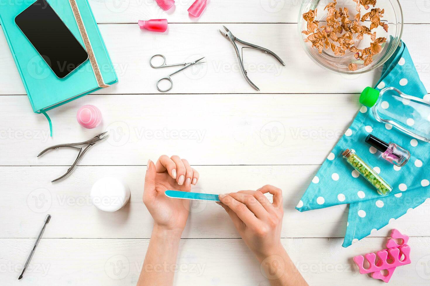 femme mains se soucier. Haut vue de magnifique lisse femme mains avec professionnel clou se soucier outils pour manucure sur blanc Contexte. photo