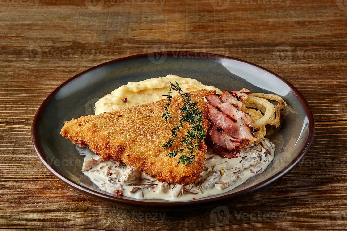 poulet schnitzel avec herbe, en purée patates et champignons sauce sur assiette sur en bois table Contexte. en bonne santé aliments. photo