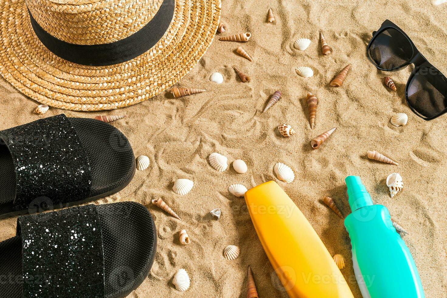 été tenue de plage, retourner flops, chapeau, des lunettes de soleil et coquillages sur le sable plage. photo