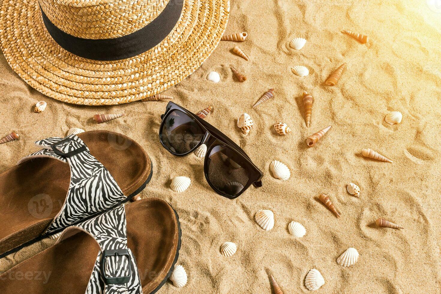 été tenue de plage, retourner flops, chapeau, des lunettes de soleil et coquillages sur le sable plage. photo