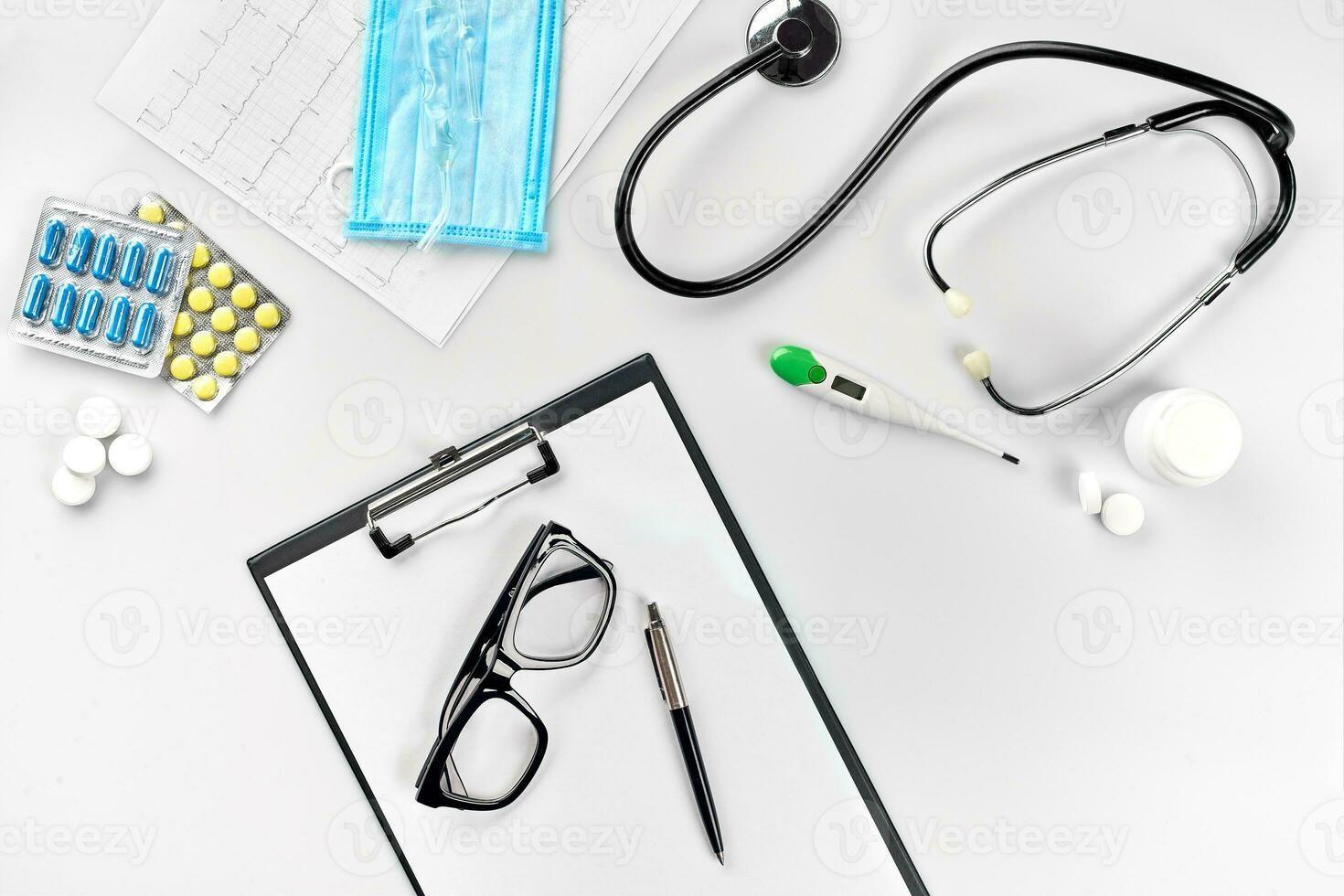 affaires ensemble pour hôpital pilules, stéthoscope, médical équipement, Remarque livre avec stylo et des lunettes sur blanc Contexte. moderne médecins ensemble sur le tableau. photo