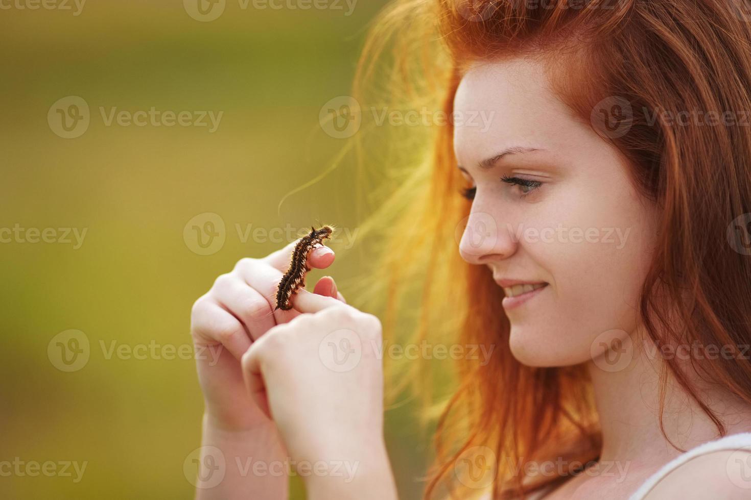 la fille tient la chenille brune sur sa main photo