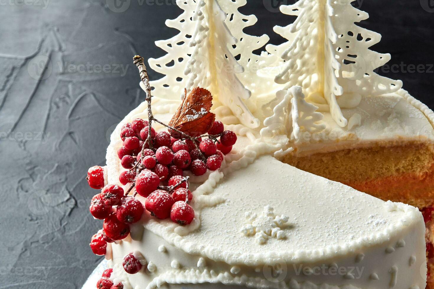 hiver gâteau couvert avec blanc glaçage, avec peint maison dans le forêt, des arbres et rouge sorbier des oiseleurs. photo