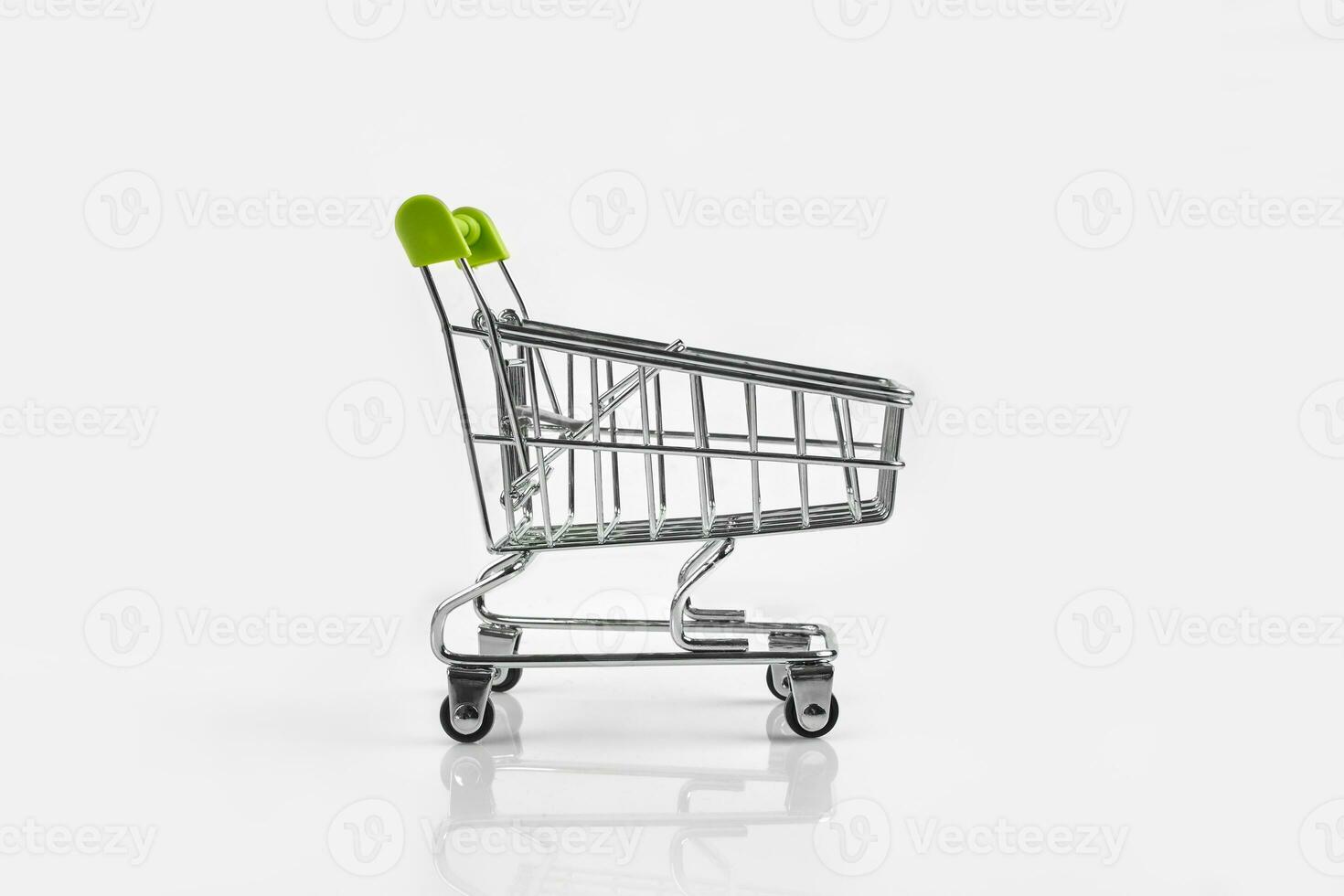 proche en haut de supermarché épicerie pousser Chariot pour achats avec noir roues sur blanc Contexte. concept de achats. photo