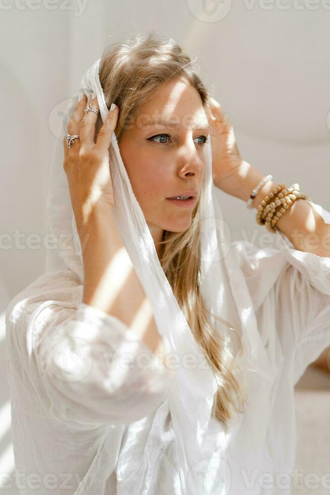 magnifique Jeune femme avec sa tête couvert. beauté fille dans hijab. mode Oriental style modèle dans blanc moderne intérieur. photo