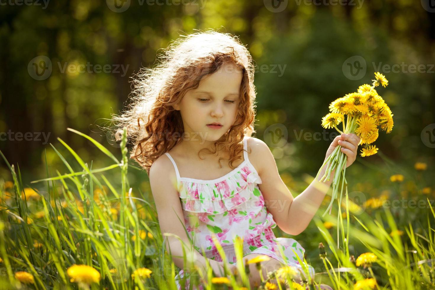 fille rassemble un bouquet de pissenlits photo