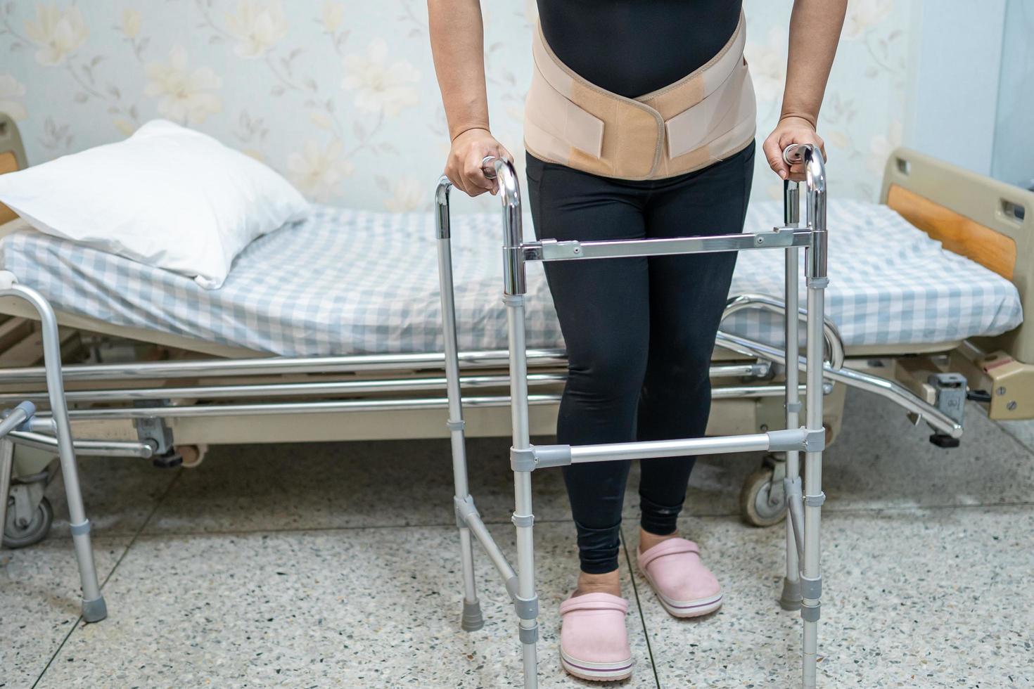 patiente asiatique portant une ceinture de soutien pour les maux de dos photo