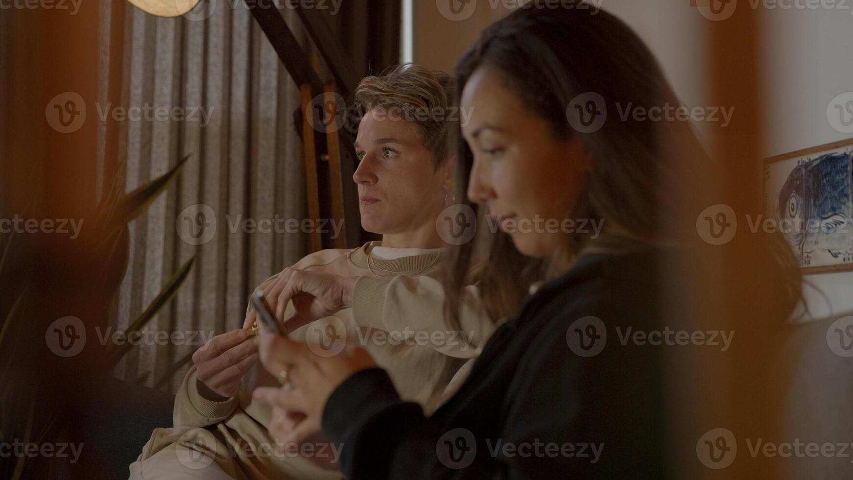 deux femmes, regarder la télévision, et, smartphone, sur, sofa photo