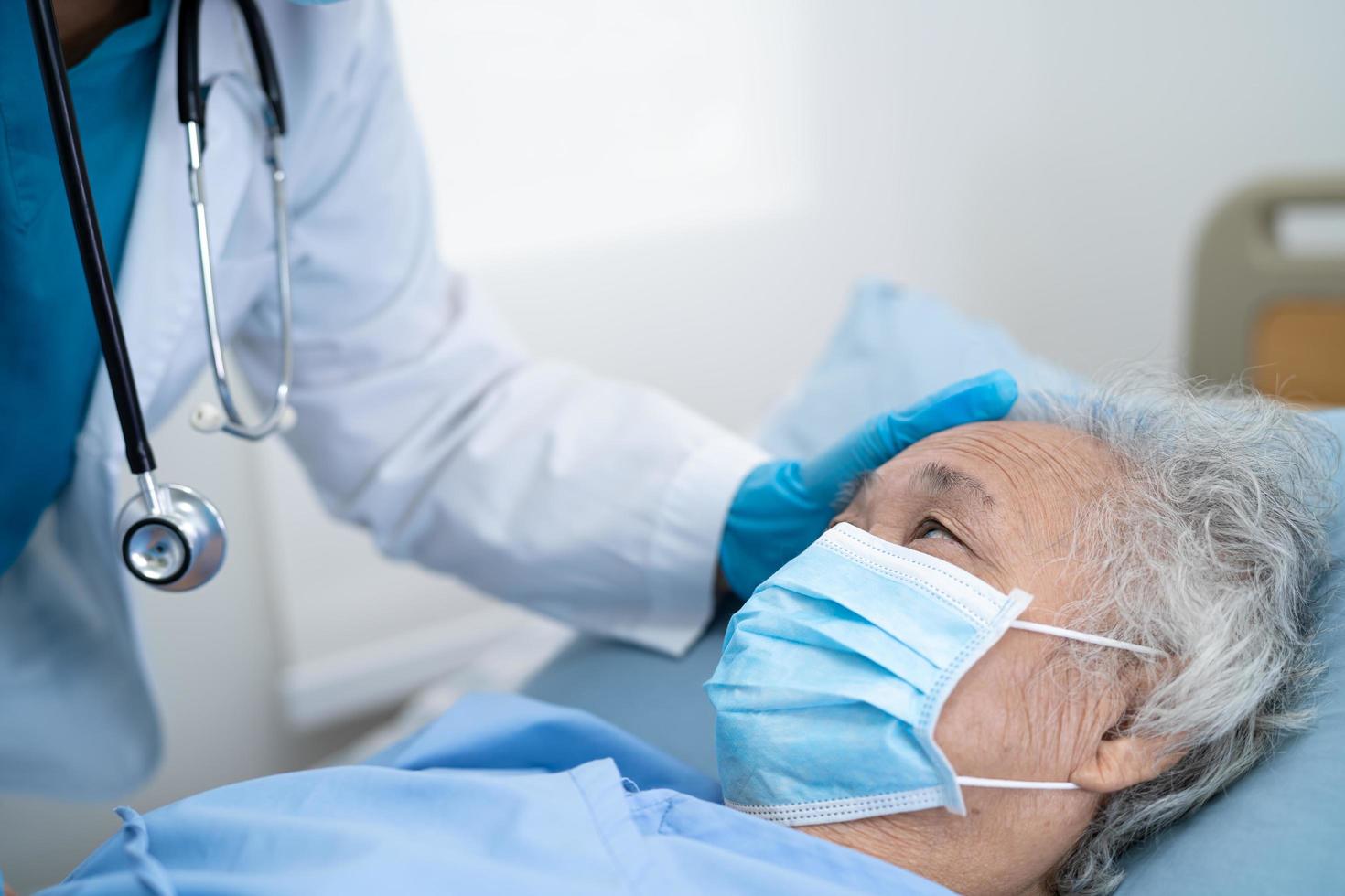 un médecin aide un patient asiatique âgé portant un masque pour protéger le coronavirus photo