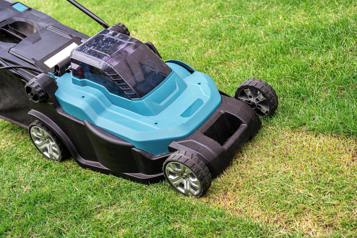 La machine de tondeuse à gazon a coupé l'herbe verte, jardin de maison de plantation de passe-temps photo