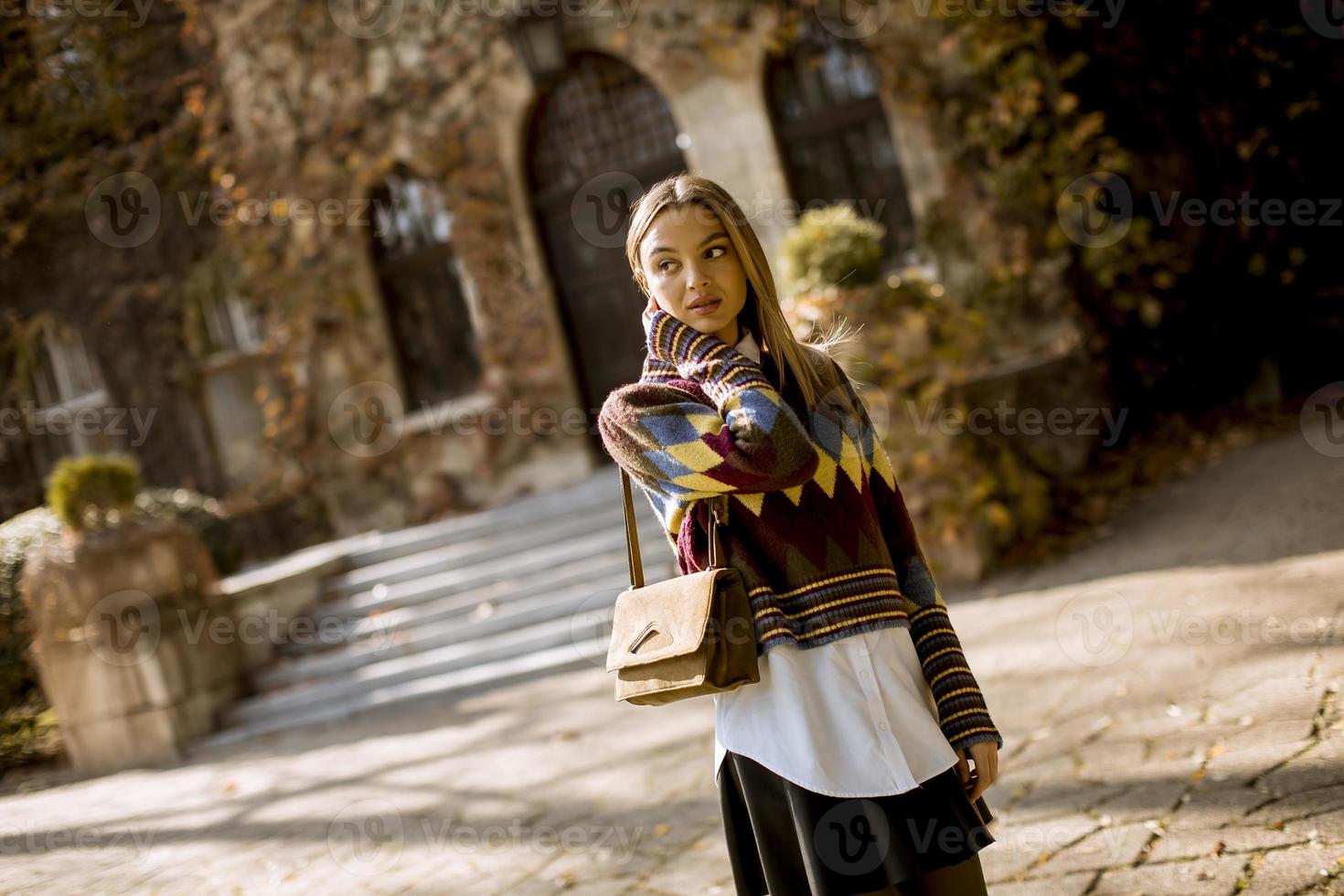 Jeune femme debout à l'extérieur au jour d'automne ensoleillé photo