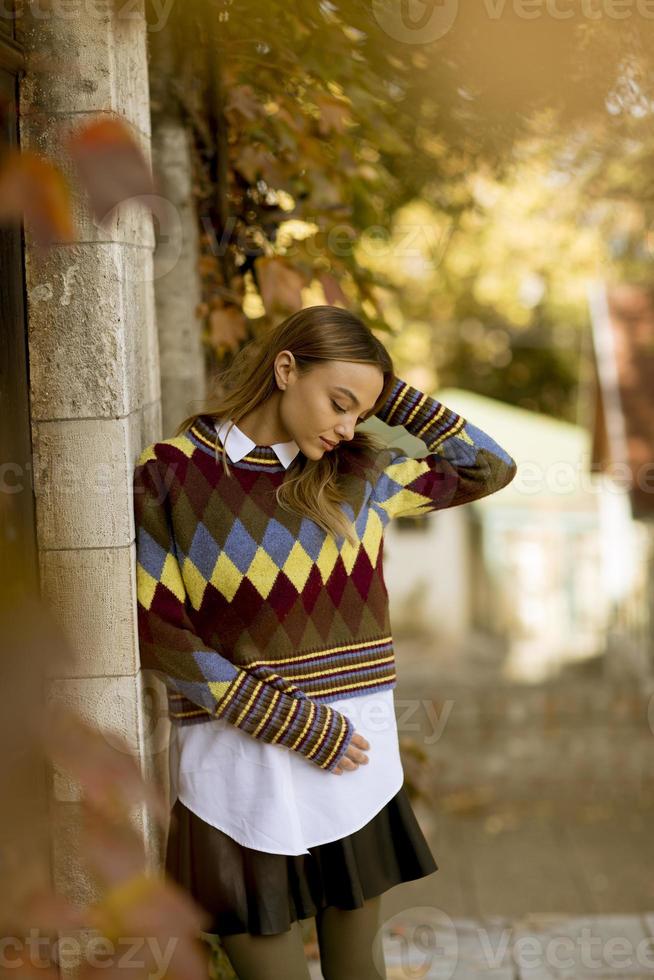 Jeune femme debout à l'extérieur au jour d'automne ensoleillé photo