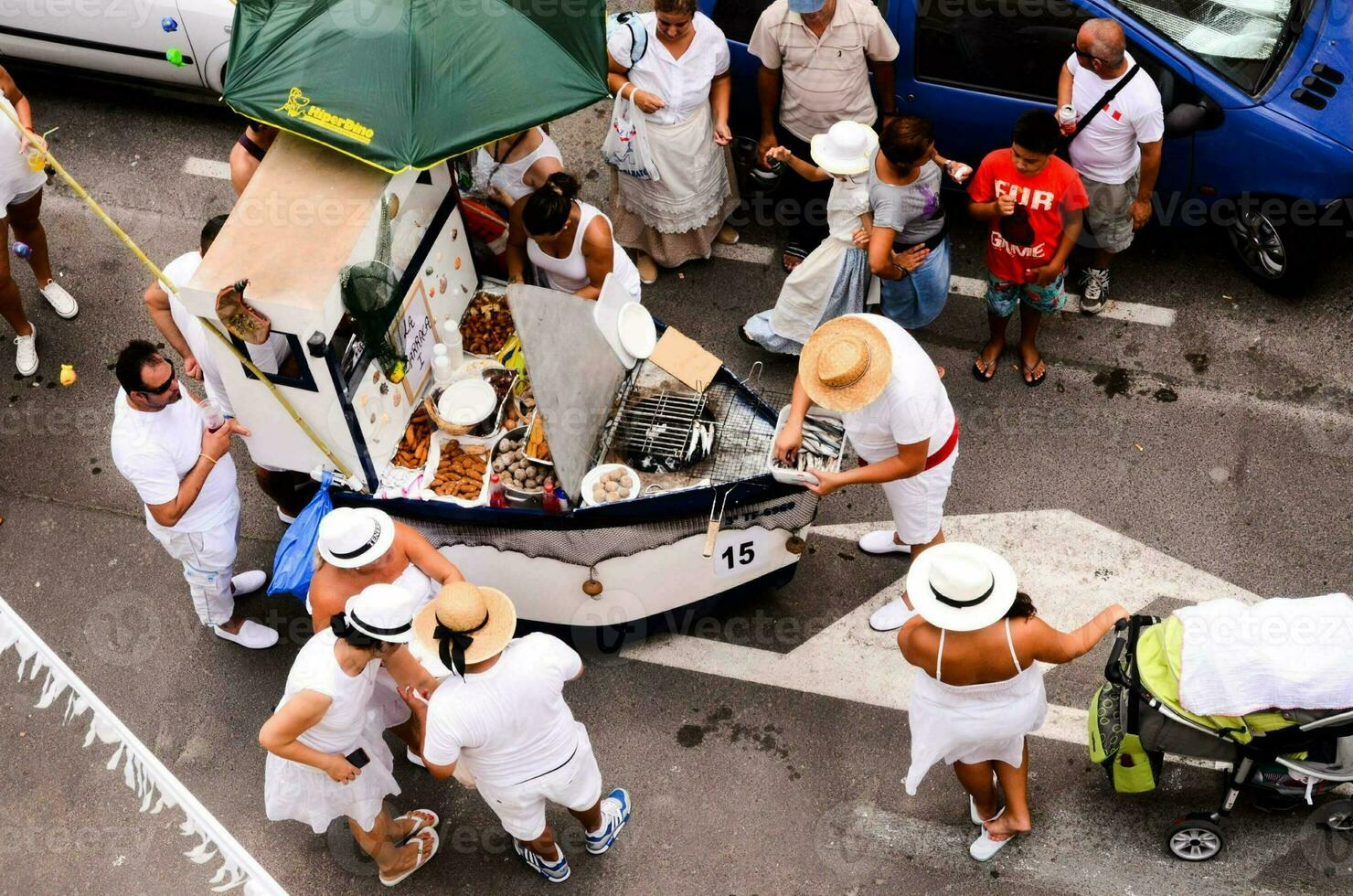 une groupe de gens dans blanc tenues sont permanent autour une Chariot photo