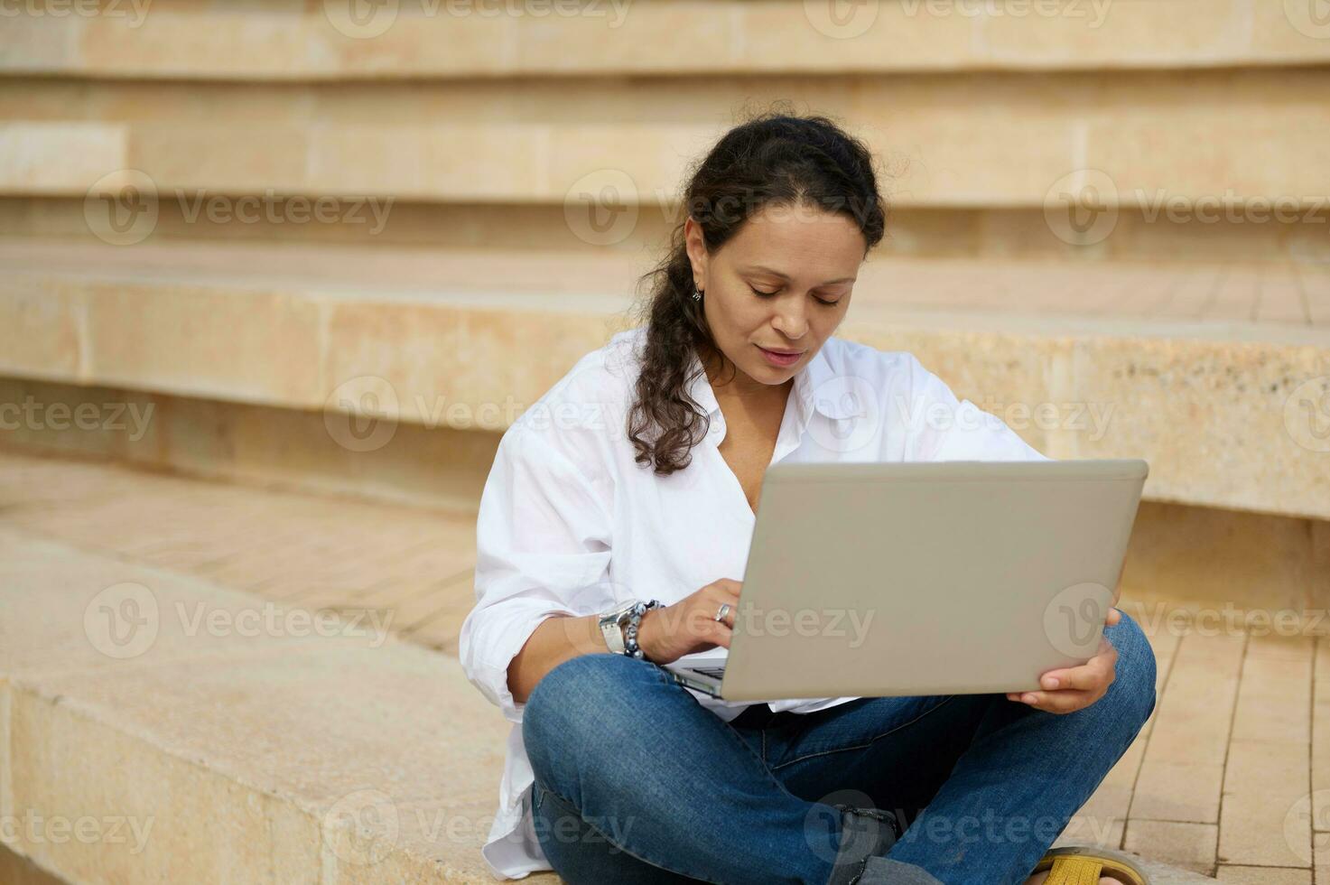 femelle étudiant séance sur pas en plein air, en utilisant portable travail sur diplôme projet. personnes. carrière. éducation Université photo