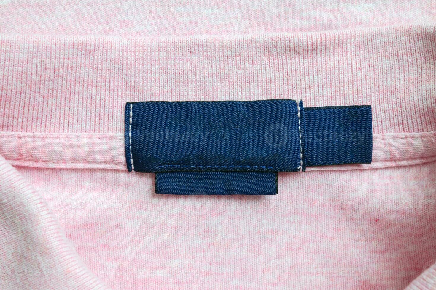 Vide bleu blanchisserie se soucier vêtements étiquette sur rose chemise en tissu texture Contexte photo