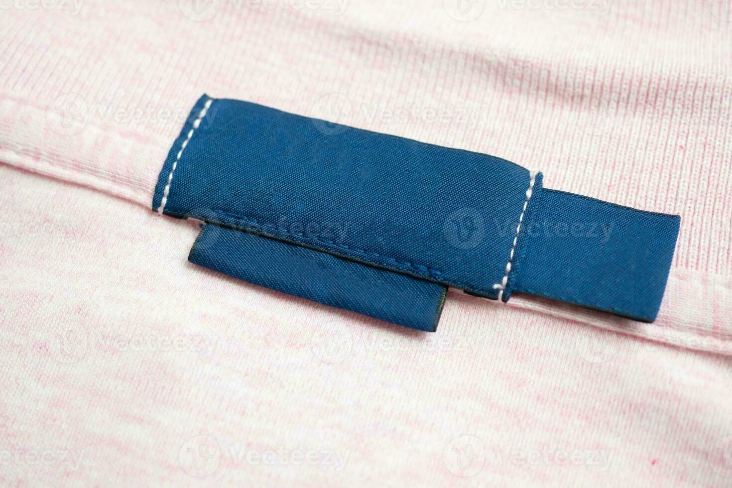 Vide bleu blanchisserie se soucier vêtements étiquette sur rose chemise en tissu texture Contexte photo