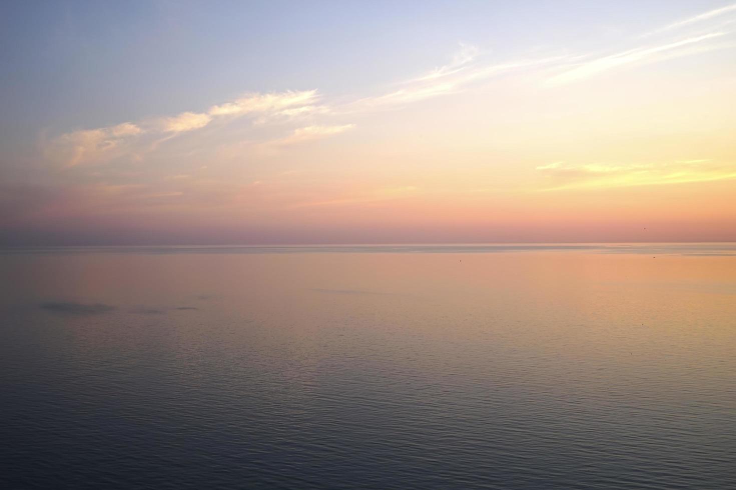 délicieux coucher de soleil délicat sur une mer calme photo